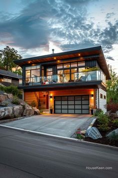 a modern house is lit up at night with lights on the windows and balconyes