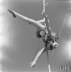 a woman is doing aerial acrobatics on a pole