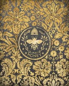 an ornate gold and black wallpaper with a bee emblem on it's side