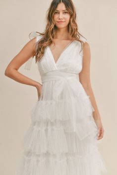 a woman wearing a white dress with tiered layers