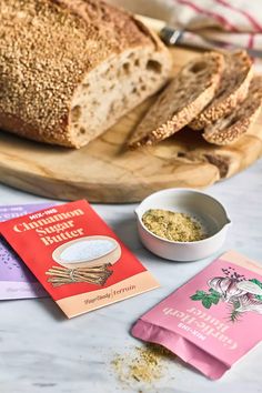 bread and spices on a cutting board next to a packet of powdered cinnamon butter