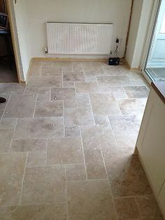 an empty room with tile flooring and a radiator on the wall next to it