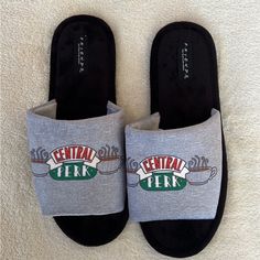 a pair of slippers with the words central perk printed on them are laying on a white carpet