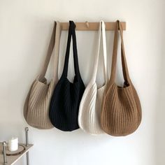 three purses hanging up on a wall