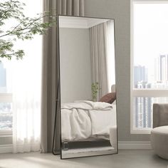 a large mirror in the corner of a room with a bed and chair next to it