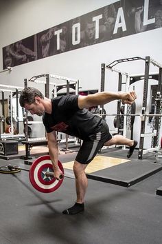 a man doing squats with a barbell in a crossfit gym area