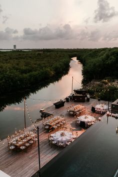 tables and chairs are set up on the dock by the water for an outdoor dinner