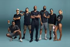 a group of people standing next to each other in front of a blue background with one person holding a toothbrush