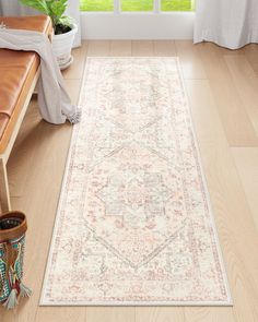 a white rug with an ornate design on the floor in front of a large window