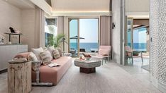 a living room filled with furniture next to the ocean