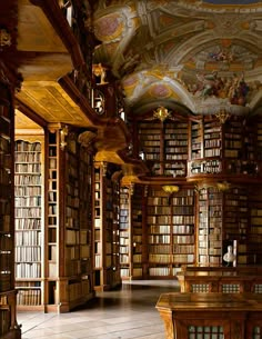 an empty library with many bookshelves and paintings on the ceiling, along with wooden tables