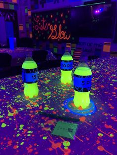 three yellow and blue water bottles sitting on top of a table covered in confetti