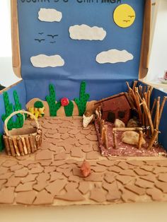 a cake made to look like a desert scene with cactus, dirt road and house