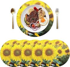 sunflowers and plates with silverware are arranged in front of a white background