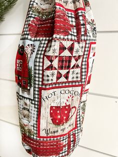 a red and white bag hanging from the side of a wall next to a christmas tree