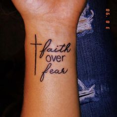 a wrist tattoo with the words faith over fear on it