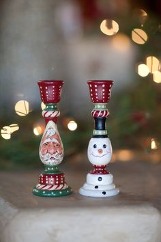 two glass candlesticks sitting next to each other