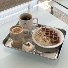 a breakfast tray with coffee, waffles and ice cream