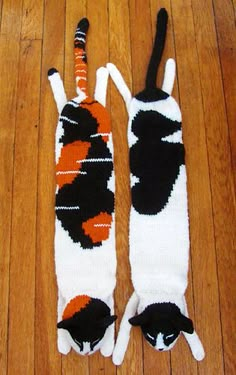 two black and white cats made out of knitted socks on wooden floor with wood flooring