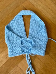 a blue knitted hat with a bow on the side sitting on a wooden floor