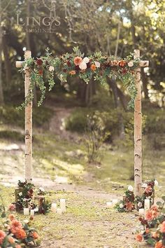 an outdoor wedding arch decorated with flowers and candles