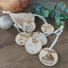 four wooden tags with different designs on them next to a potted plant and silver ornament