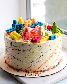 a birthday cake with legos on it and sprinkles all over the top