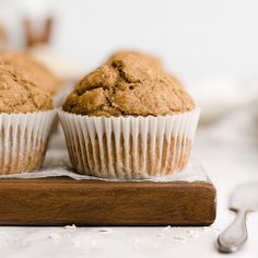 two muffins sitting on top of a wooden cutting board