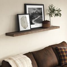 a brown couch sitting next to a wooden shelf