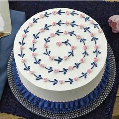 a white and blue cake with pink flowers on it