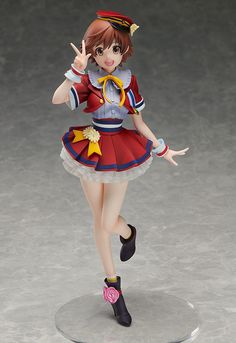 a figurine is posed on top of a round base with her hand in the air