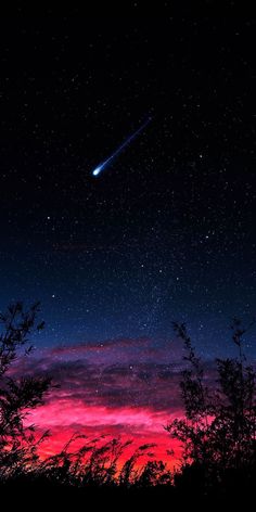 the night sky is filled with stars and bright pink clouds, as well as a shooting star