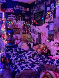 a bed with many stuffed animals on it in a room filled with posters and lights