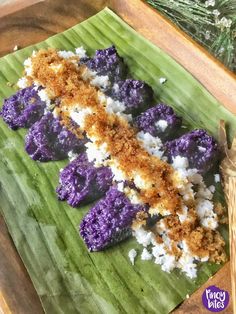 purple and white food sitting on top of a banana leaf