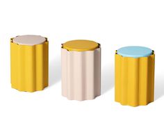 three different colored stools sitting next to each other