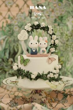 a white cake with two bunnies on top of it