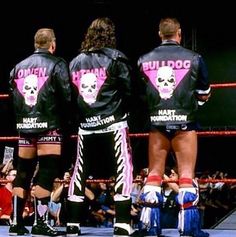 two men standing next to each other in front of a crowd wearing jackets with skulls on them