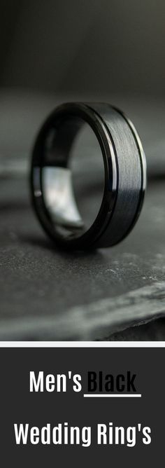 men's black wedding ring on top of a table with the words, men's black wedding ring's