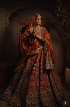 a woman in a red and gold bridal gown