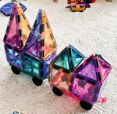 three colorful toy cars sitting on top of a white carpet