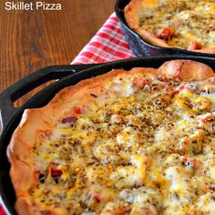 two pizzas sitting in pans on top of a table