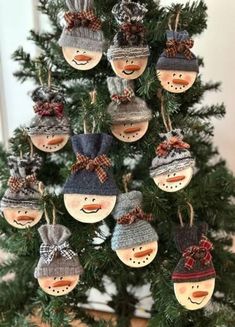 a christmas tree with snowman ornaments hanging from it's branches and decorations on the top