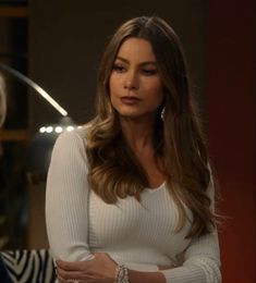 a woman in a white top standing next to a zebra print chair and looking at the camera