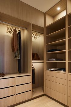 an empty walk - in closet with wooden shelves and drawers