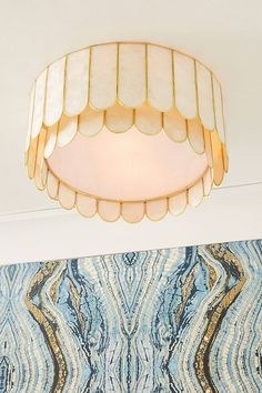 a light fixture hanging from the ceiling in a room with blue and white wallpaper