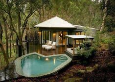 a small house with a pool in the middle of it and some chairs around it