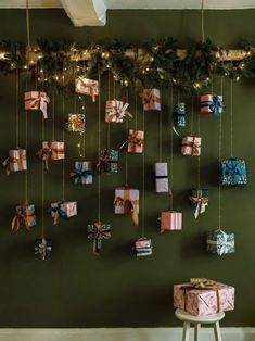 christmas presents are hung on the wall with garland and lights around them, as well as bows