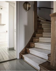 an open door leading to a staircase with carpeted steps and wood trimmings