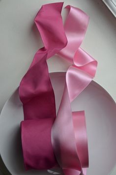 two pieces of pink satin ribbon on a white plate