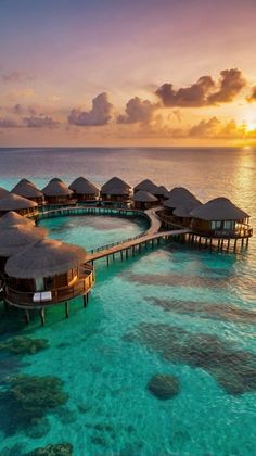 the water is crystal blue and has overhangs that are lined with straw huts